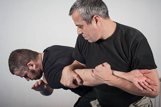 Kapap instructor demonstrates arm bar techniques with his student